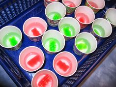 there are many cups with different colored liquid in them on the tray, and one is empty