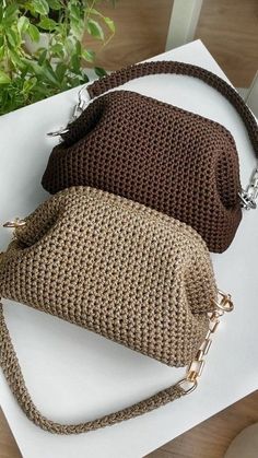 two purses sitting on top of a white table