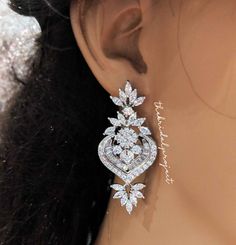 a close up view of the back of a woman's head wearing diamond earrings