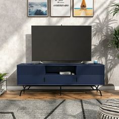 a living room scene with focus on the entertainment center and large screen tv mounted to the wall