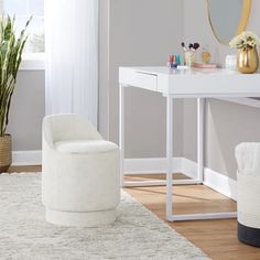 a white chair sitting in front of a mirror on top of a desk next to a potted plant