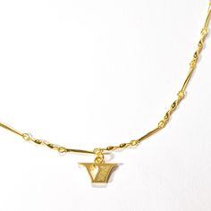 We transformed the font used in our logo—and on U.S. currency—into gold letter necklaces so that you can channel in your own personal fortune. This "V" letter charm sits on an adjustable twisted bar chain that you can wear as a choker or everyday pendant. It's embellished with subtle Mother of Pearl enamel detailing along the side and our signature wave engraving on back. This initial necklace is equal parts self expression jewelry and gift-worthy keepsake for all the Vs in your life. Charm Dime Chain Necklace With Logo Charm As Gift, Everyday Pendant, V Letter, Initial Necklaces, Gold Letter Necklace, Self Expression, Gold Letter, Letter Charm, Wave Design