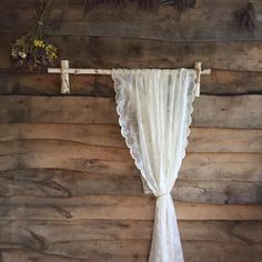 an old curtain hanging on the side of a wooden wall