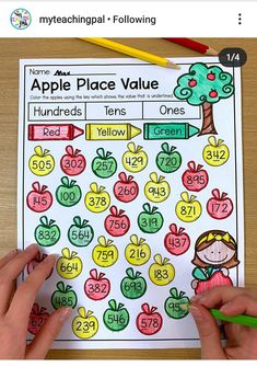 hands holding pencils over an apple place value game