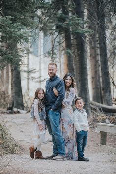 a man and two children are standing in the woods with their arms around each other