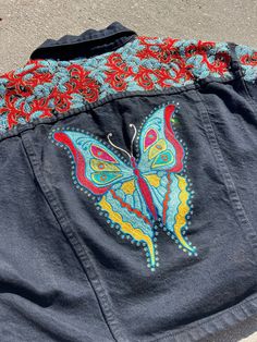 "This is a fabulous one-of-a-kind rhinestone encrusted and custom chainstitch/satinstitch embroidered black denim jacket in a Women's size Medium. The jean jacket brand that was customized is Bongo and is a short jacket with blousy denim sleeves. The embroidery features sky blue satinstitched leaves outlined in silver and gold-bordered red vines, all dotted with clear sparkly rhinestones, covering the front, front yoke, back yoke and top of sleeves. The back prominently displays a big, bright an Bohemian Embroidered Multicolor Denim Jacket, Bohemian Embellished Denim Jacket For Fall, Bohemian Embellished Denim Jacket, Swallow Tail Butterfly, Denim Sleeves, Vintage Western Wear, Boho Hippie Style, Red Vines, Chain Stitch Embroidery