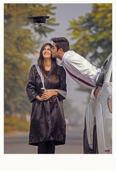 a man and woman standing next to each other near a car with a graduation cap on their head