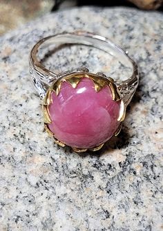 This ring is old store stock- unworn. It is top quality vintage pink genuine ruby. It is sterling silver which is plated with white and yellow gold. This means it won't tarnish. The ruby is 5/8 of an inch or 12mm around. It retailed at $102 and comes in a tiny ring box. Pink Round Heirloom Jewelry, Pink Cabochon Jewelry For Anniversary, Pink Round Cabochon Ruby Ring, Pink Cabochon Ruby Ring Gift, Pink Cabochon Ruby Ring, Certified Pink Sapphire Ring For Gift, Handmade Pink Ruby Ring For Anniversary, Classic Pink Cabochon Jewelry, Handmade Pink Ruby Anniversary Ring