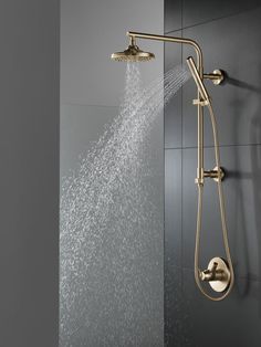 the shower head is spraying water from it's sprinkles on the wall