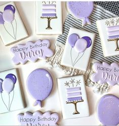 some cookies are decorated with purple icing and balloons