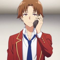 a man in a red jacket talking on a cell phone while wearing a blue tie