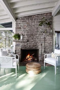 a living room with a fire place and wicker furniture