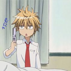 an anime character holding a cell phone up to his ear and looking at it in bed