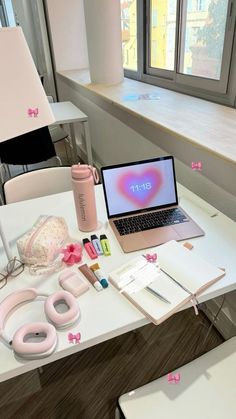 an open laptop computer sitting on top of a white desk next to a pink bag