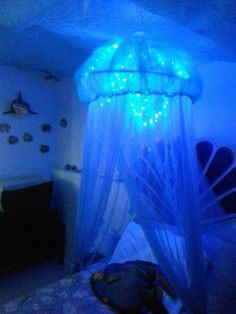 a bed room with a canopy and some lights on it's headboard in the corner