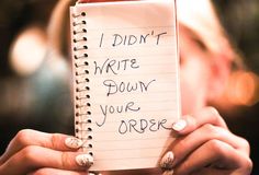 a woman holding a notepad with writing on it that says i didn't write down your order