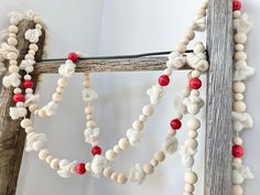 an old wooden ladder is decorated with white and red beads