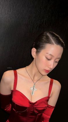 a woman in a red dress with a cross necklace