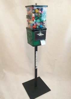 a machine that is sitting on top of a black stand with lots of balls in it