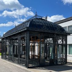 a black metal structure sitting on the side of a road