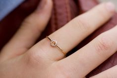 a close up of a person's hand with a diamond ring on their finger