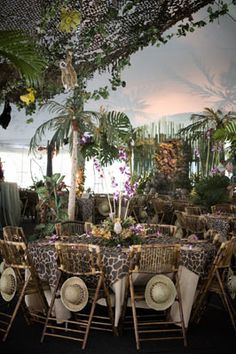 the tables are set up with animal print cloths and place settings for guests to sit at