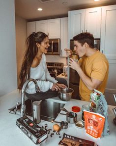 a man and woman sitting at a kitchen counter