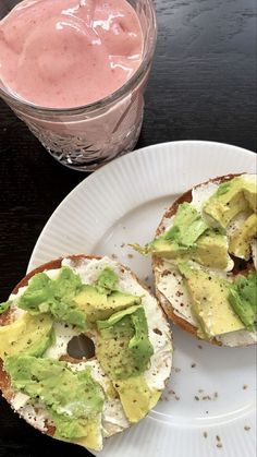 two pieces of bread with avocado on them and a pink drink in the background