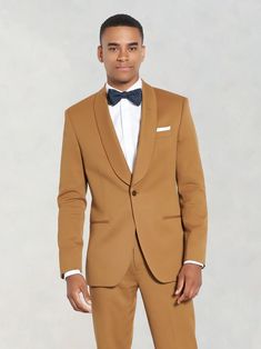 a man in a tan suit and bow tie