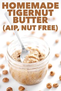 homemade tigernut butter is in a small jar with a spoon on the side and nuts scattered around it