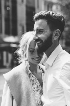 black and white photograph of a man and woman smiling at each other in the street