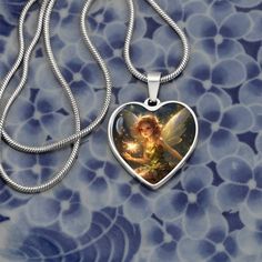 Discover the magic and strength of the Ellyllon Wales Fairy with our Fairy Heart Pendant, a masterpiece designed to exceed your highest expectations and bring enchantment into the life of someone special. This astonishing necklace, featuring a meticulously engraved design of the Ellyllon Wales Fairy on the heart pendant, is not just a piece of jewelry; it's a token of love, strength, and protection. Crafted from high-quality surgical steel with a liquid glass coating for a shatterproof finish and an optional 18k gold finish, this pendant is a testament to enduring love and the mystical power of nature's guardians. Made in the U.S by talented working moms, this piece celebrates strong communities and the spirit of craftsmanship. Embrace the Ellyllon Wales Fairy's blessings of strength and p Fairy Pendant Jewelry Gift, Spiritual Heart-shaped Gemstone Necklace, Fairy Dust Necklace, Fairy Wing Necklace, Spiritual Multicolor Heart-shaped Necklace, Fairy Heart, Fairy Jewelry, Glass Coating, Engraved Design