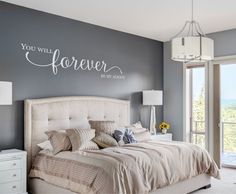 a bedroom with a large bed and a wall decal that says you will forever