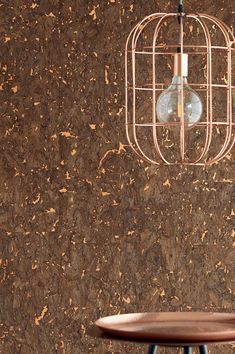 a birdcage hanging from the ceiling next to a table with a stool underneath it