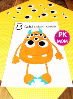 an orange monster cut out on top of a piece of paper that says 8 add eight eyes