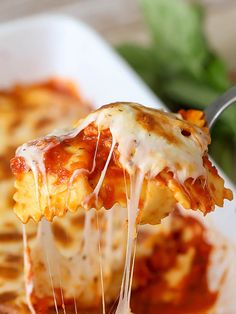 a slice of lasagna being lifted from a casserole dish with cheese and sauce