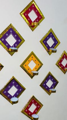 many square shaped objects are arranged on a white surface with gold and purple trimmings