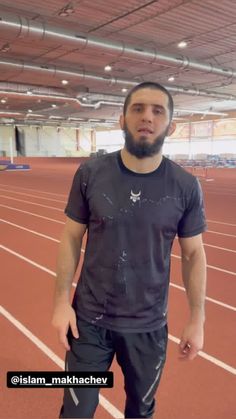 a man with a beard standing on a track