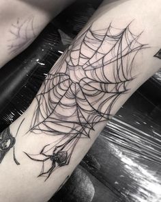 a spider web tattoo on the arm