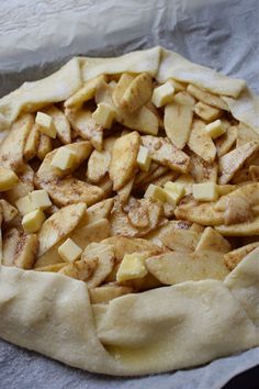 an uncooked apple pie sitting on top of a piece of paper