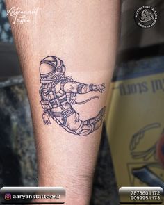 a man with a tattoo on his arm that has an astronaut drawing on the side