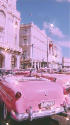 an old pink convertible car parked in front of a white building on a city street