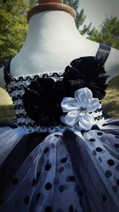 This fancy and adorable dress will definitely make a statement! A black and white striped crochet top is adorned with two black sequined flowers and a white flower with center rhinestone. Black and white tulle are used to make this adorable look along with a bit of black polka dot tulle for a fun touch. Black straps are attached and tie in a lovely bow in the back of the dress. Sizes 4t and above are made with a fully lined top. Sizes 12-18 months and above are made with either a solid black or Black Fitted Tutu Dress, Cute Style, Cute Fitted Black Tutu Dress, Fitted Tutu Dress With Sequins For Summer, Fitted Sequin Tutu Dress For Summer, Fitted Summer Tutu Dress With Sequins, Embellished Fitted Tutu Dress For Dress-up, Fitted Embellished Tutu Dress For Dress-up, Striped Crochet Top, White Tulle Dress