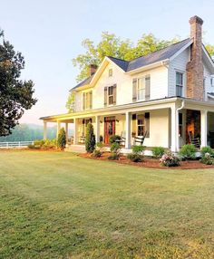 a large white house sitting on top of a lush green field