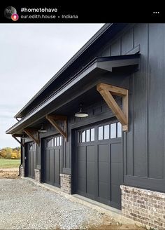 an image of a black garage with brick and wood trim on the side of it