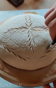 a person is making a snowflake out of dough