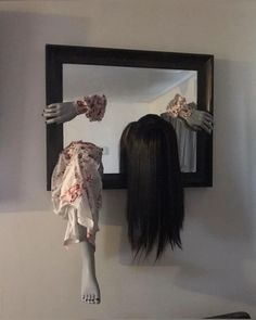 a woman's head is shown in front of a mirror with her hands reaching for the mannequin