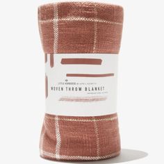 a roll of brown and white plaid flannel fabric on a white background with the words, woven throw blanket