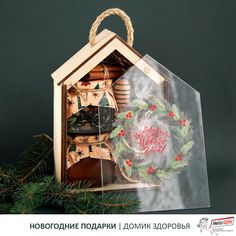 a christmas ornament in the shape of a house with a wreath on top