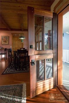 an open door leading to a dining room and patio area with wooden furniture on either side